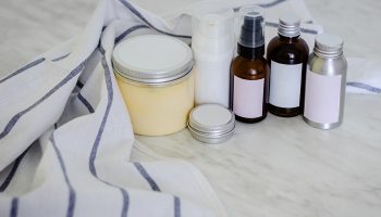 Cosmetic bottles and containers with blank label for branding mock-up on marble background