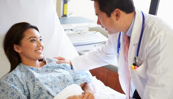 Doctor Talking To Female Patient On Ward