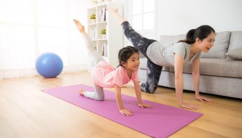 asian pretty mother and her youth kid daughter in the gym center doing stretching fitness exercise yoga together, parent accompany children sport concept.
